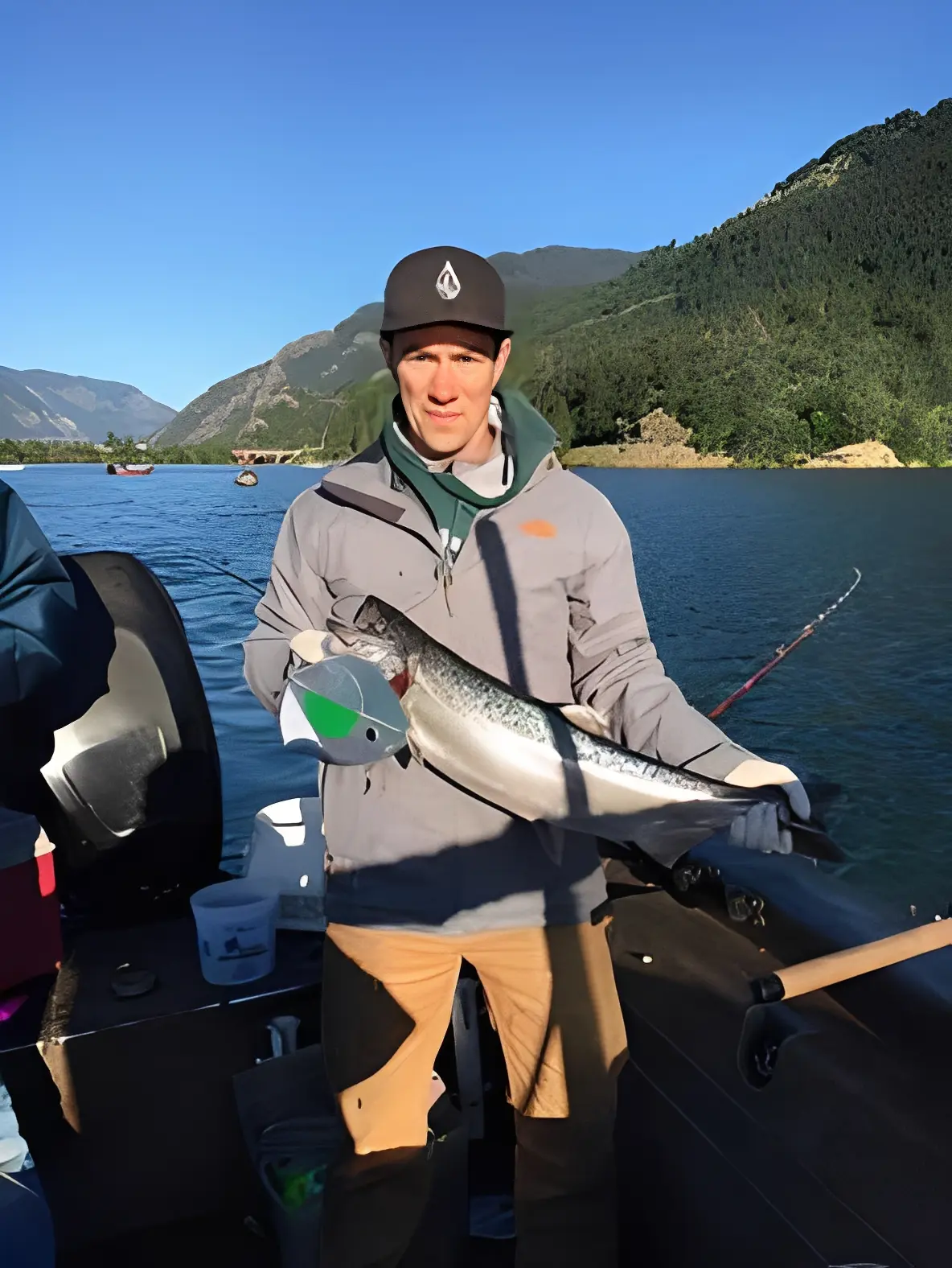Man holding fish on a boat.