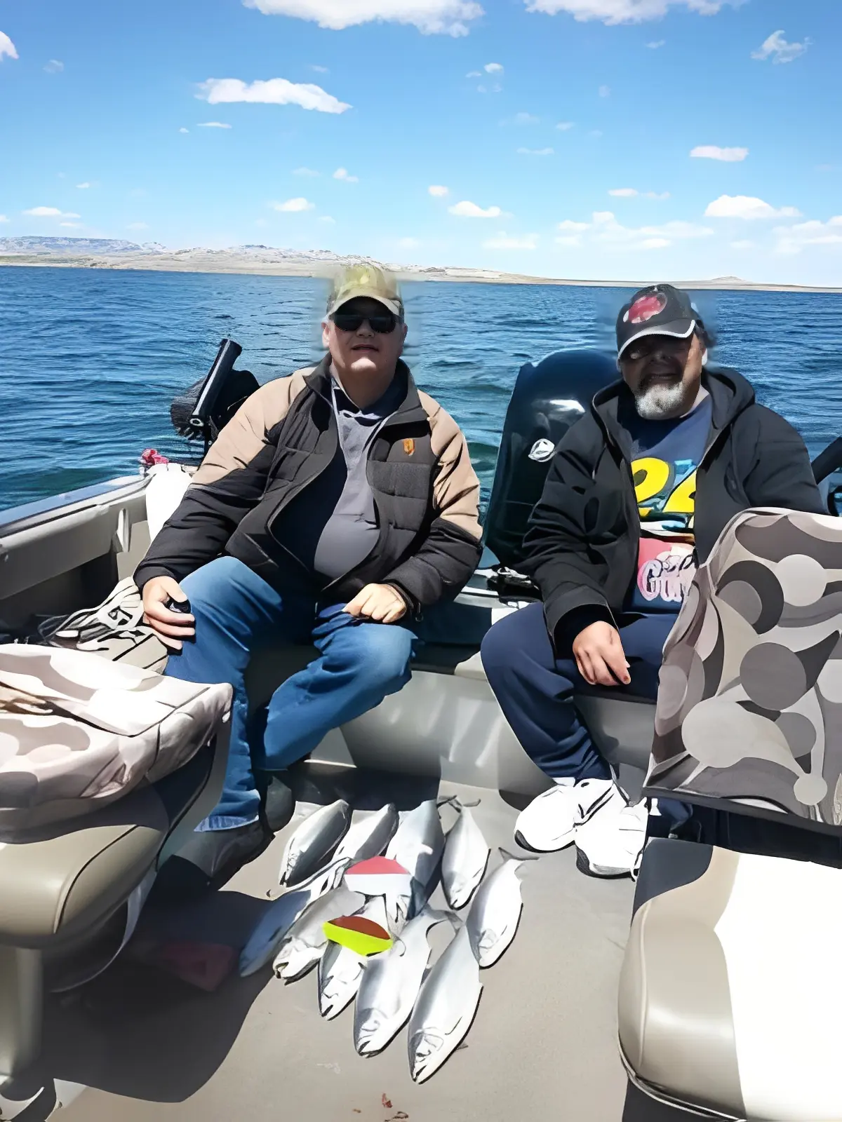 Two men on a boat with fish.