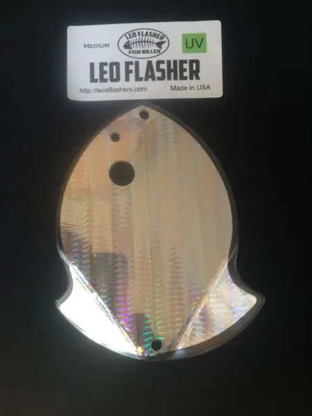 Reflective fish-shaped LED flasher with a textured surface.