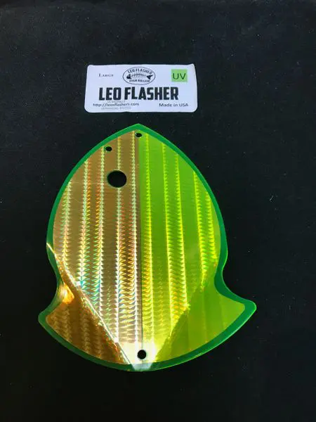 Green and gold LED flasher cover with a reflective surface.