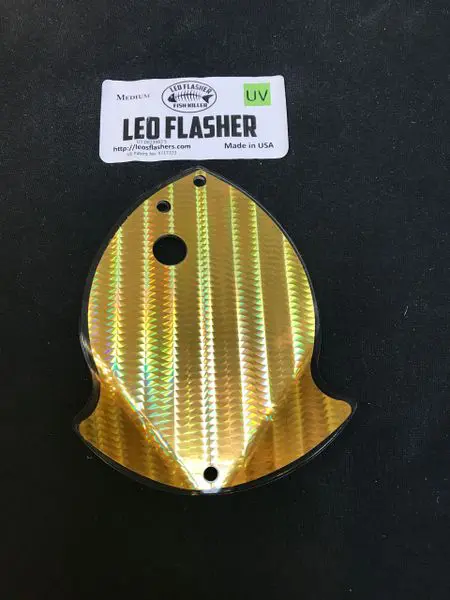 Gold-colored LED flasher cover with a carbon fiber pattern.