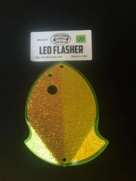 A glittery yellow and green fish-shaped Leo Flasher keychain.