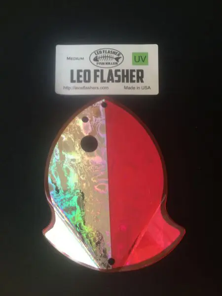 A red fish-shaped LED flasher keychain with holographic details.