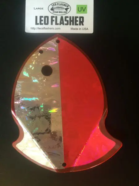 A red and silver rocket-shaped reflective object with a sign above it.