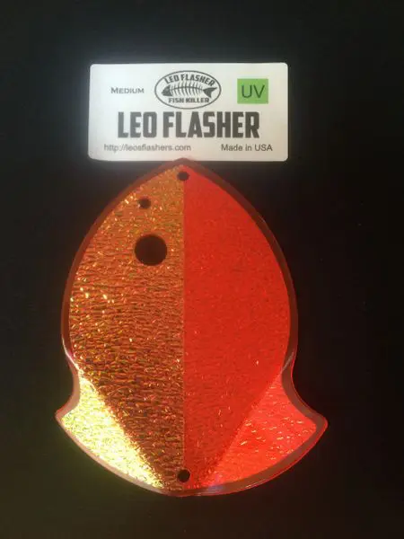 Orange LED flasher shaped like a fish, glittery on one side.