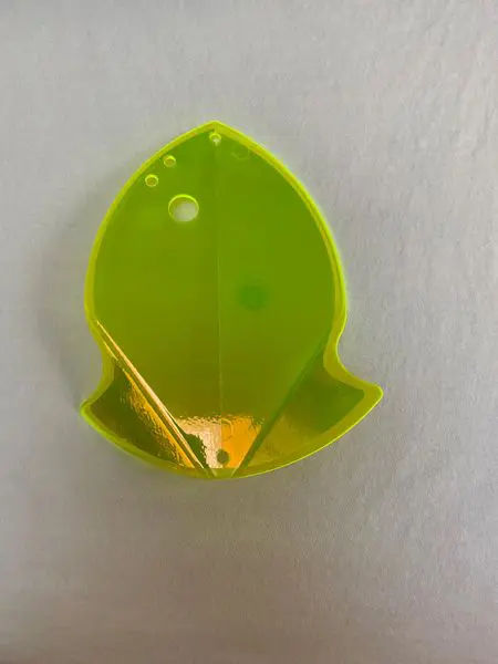 A small green plastic leaf-shaped container on a white surface.
