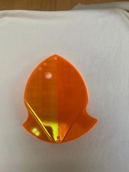 Orange translucent plastic object with a unique shape on a white background.