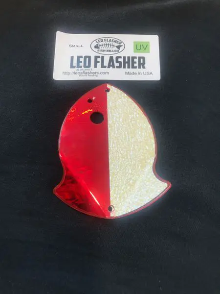 A red and white fish-shaped reflector with a hole for mounting.