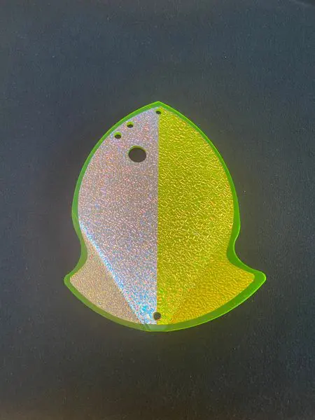 A reflective, split-color safety marker shaped like a fish.