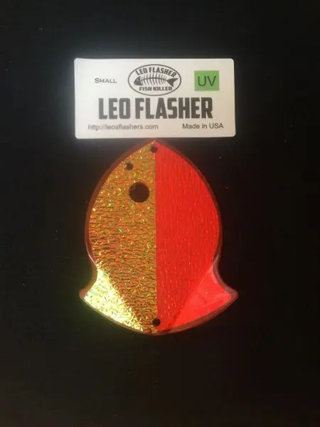 A glittery orange and red LED flasher fishing lure.