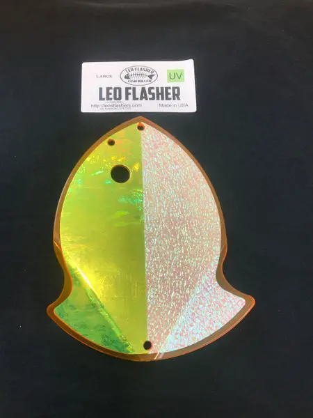 A shiny, leaf-shaped LED flasher light with green and gold colors.