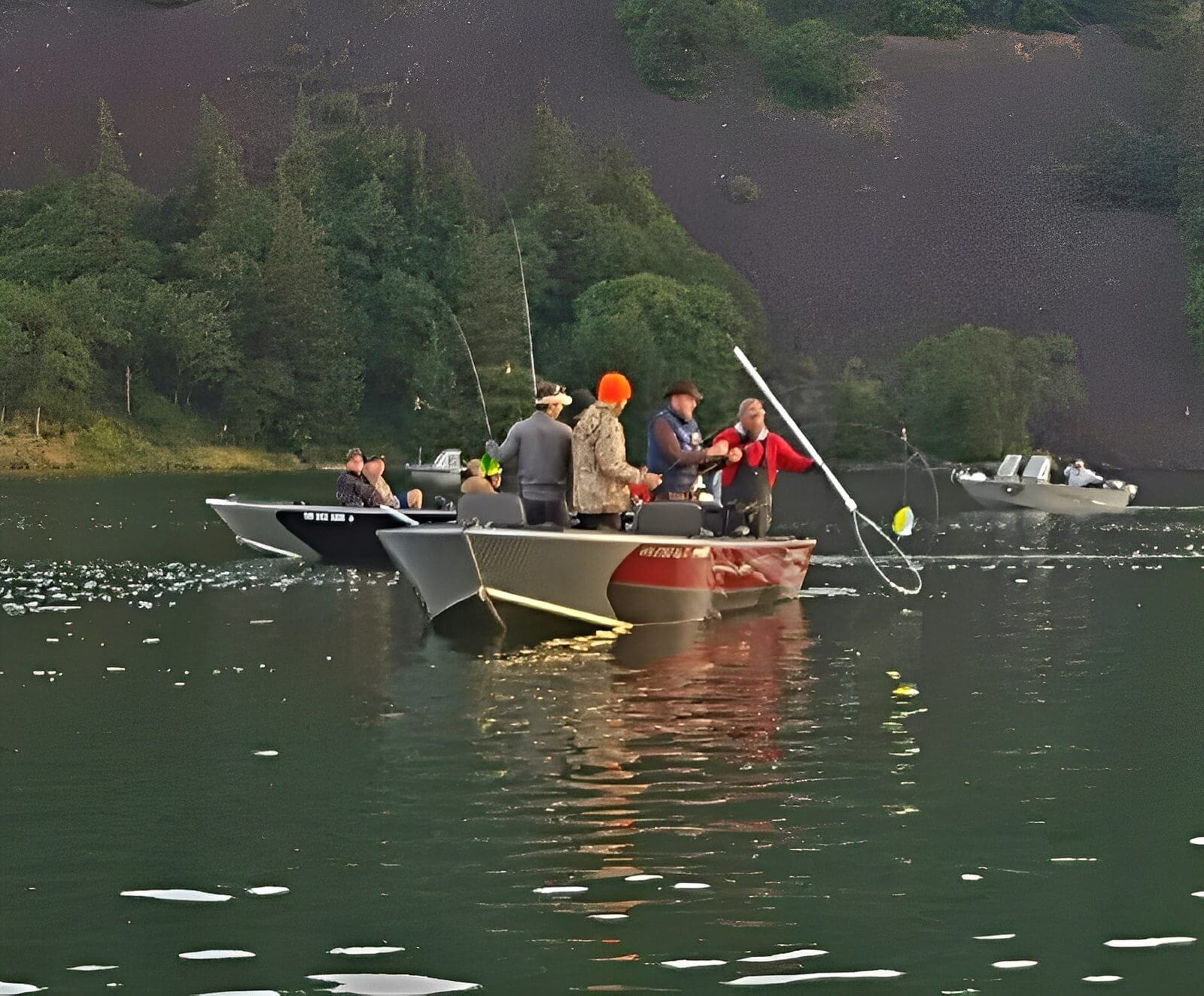 Boats with people fishing on a lake.