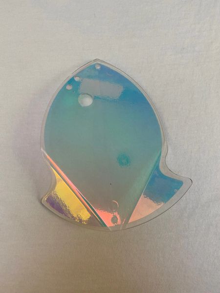 A shiny, iridescent whale-shaped object on a white surface.