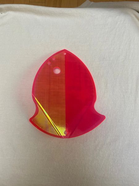 A red and yellow translucent plastic clip on a white surface.